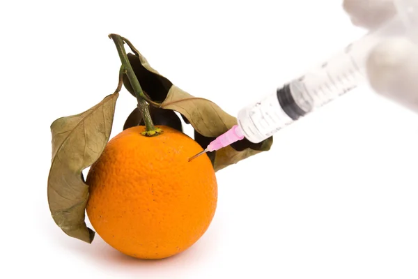 Dar una inyección a una naranja demasiado madura sobre un concepto médico blanco — Foto de Stock