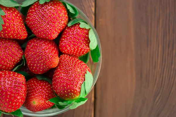 Oversiktsskål med jordbær på tre – stockfoto