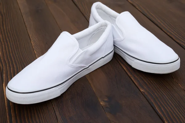 Ζευγάρι άσπρα αθλητικά παπούτσια σε ξύλο — Φωτογραφία Αρχείου