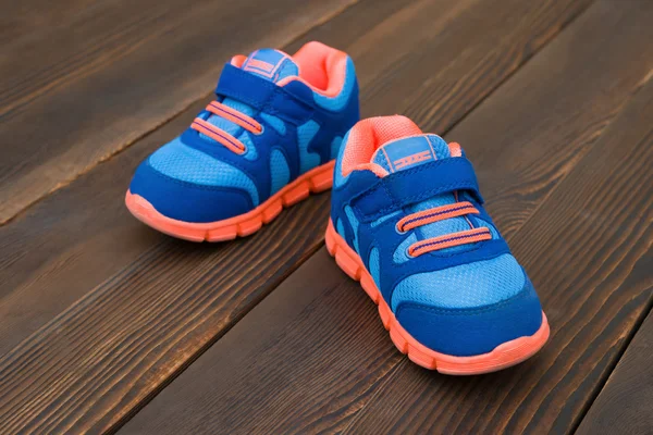 Par de zapatos deportivos azules para niño en madera — Foto de Stock