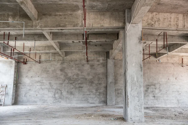 Leere Industrielokale vor architektonischem Hintergrund mit nackten Zementwänden, Fußböden und Säulen, die ein Zwischengeschoss stützen — Stockfoto