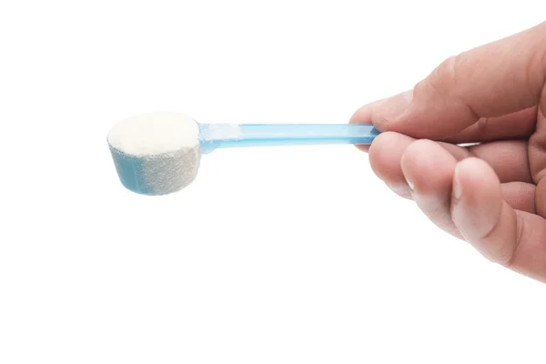 Hand holding a blue spoon of powdered milk with clipping path — Stock Photo, Image