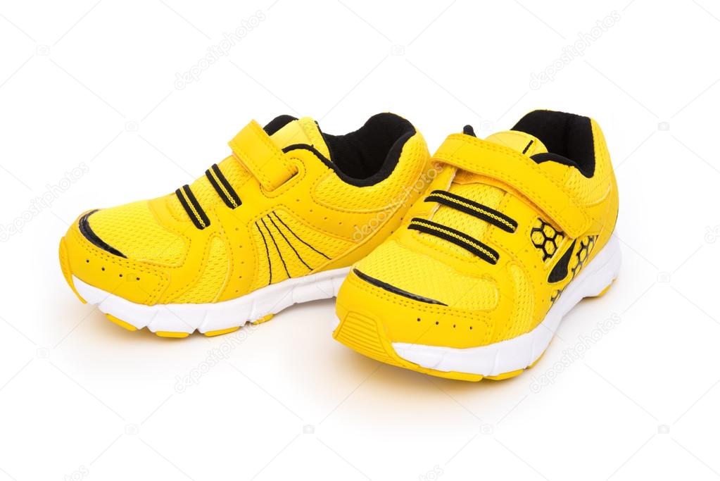 Pair of yellow sporty shoes for kid on a white background