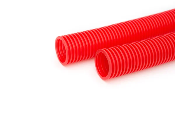 Red plastic pipes on a white background — Stock Photo, Image