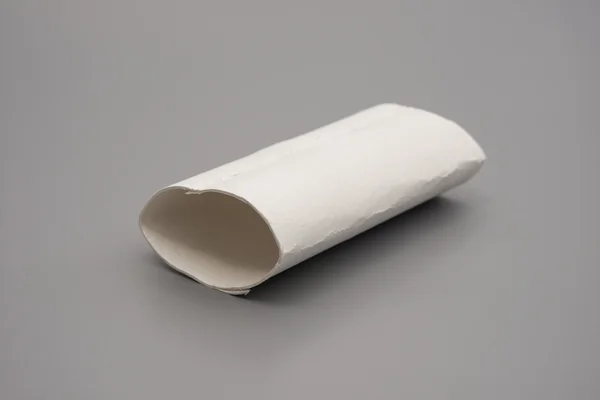 Rotolo di carta igienica rotto con l'ultimo pezzo di tessuto su grigio — Foto Stock