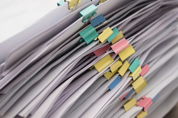 Pile of documents with colorful clips stack up — Stockfoto