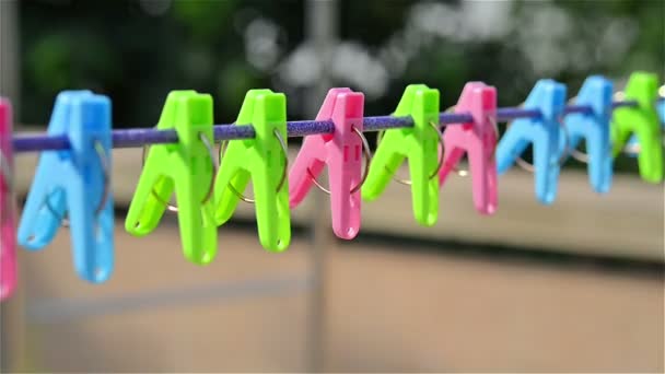 Clothespins hanging on steel wire in wind — Stock Video