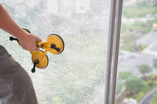 Taking out on a broken window with suction plate — Stock Photo, Image