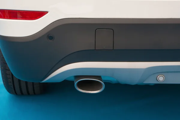 Exhaust pipe of a white car on blue carpet — Stock Photo, Image