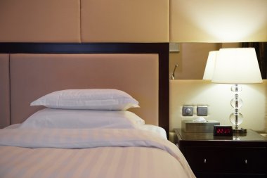 Bir otel odasında yatak ve lamba.