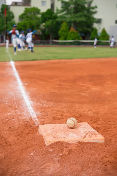 Baseball och bas på baseball området med spelare öva på bakgrund — Stockfoto