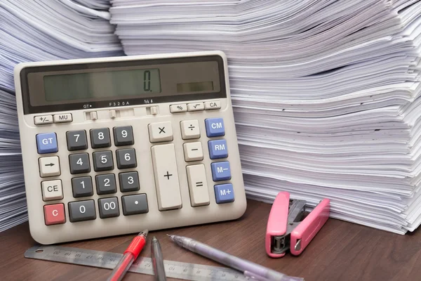 Montón de documentos en el escritorio apilar en alto con la calculadora pluma y regla en el escritorio de la oficina — Foto de Stock