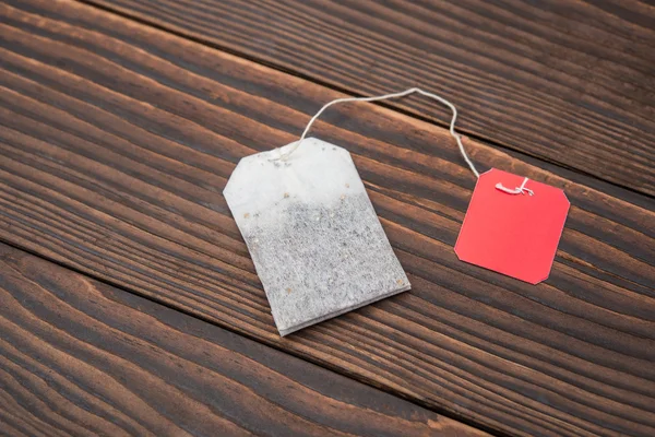 Top vista teabag com etiqueta em branco em um fundo de madeira — Fotografia de Stock