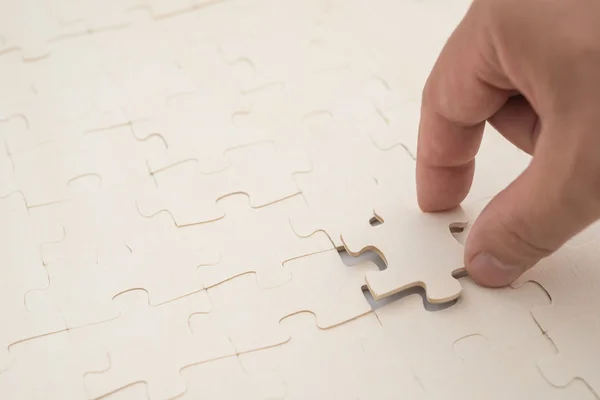 Het laatste stukje van een puzzelspel op witte afwerking — Stockfoto