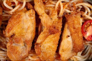 Tavada kurutulmuş tavuk göğsü ve yatay kompozisyonda spagetti.