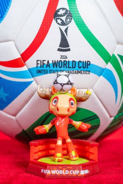 ZHONGSHAN Çin-12 Aralık 2025: resmi maskot Maple ve 2026 FIFA Dünya Kupası için kırmızı üzerine dikey kompozisyon.