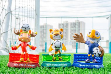 ZHONGSHAN Çin-14 Aralık 2025: 2026 FIFA Dünya Kupası resmi maskotları yatay kompozisyonda bir futbol sahasında.
