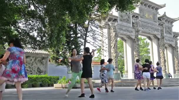 Zhongshan Guangdong China - 22 Aug, 2015: Een groep Chinese vrouwen dansen met muziek voor een park in de ochtend op 22 Aug, 2015, in Zhongshan, Guangdong, China. Square dance is erg populair in — Stockvideo