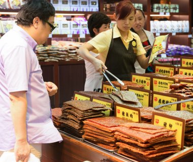 Visitors buying beef jerky in Macao clipart