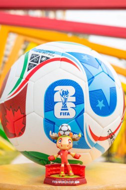 ZHONGSHAN Çin-14 Aralık 2025: resmi maskot Maple ve 2026 FIFA Dünya Kupası futbolu dikey kompozisyonda renkli çerçevelerin önünde.
