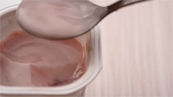 Comer yogur sabor fresa de cerca — Vídeo de stock