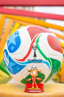 ZHONGSHAN Çin-14 Aralık 2025: resmi maskot Maple ve 2026 FIFA Dünya Kupası futbolu dikey kompozisyonda renkli çerçevelerin önünde.