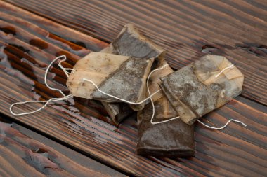 used teabags on a wooden background clipart