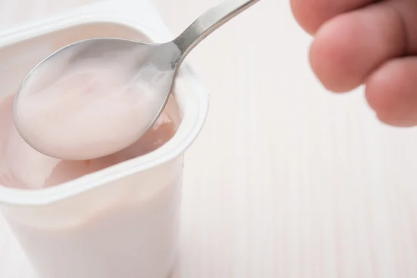 Eating strawberry flavor yogurt close up — Stock Photo, Image