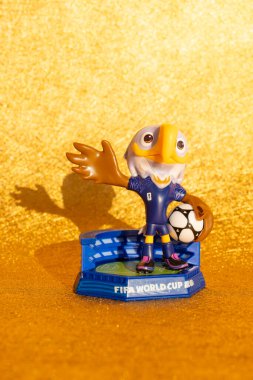 ZHONGSHAN Çin-15 Aralık 2025: 2026 FIFA Dünya Kupası resmi maskotları dikey kompozisyonda altın bir zemin üzerinde Clutch.