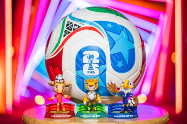 ZHONGSHAN Çin-16 Şubat 2026: resmi maskotlar ve 2026 FIFA Dünya Kupası için futbol geceleri yatay kompozisyonda renkli ışıklar önünde.