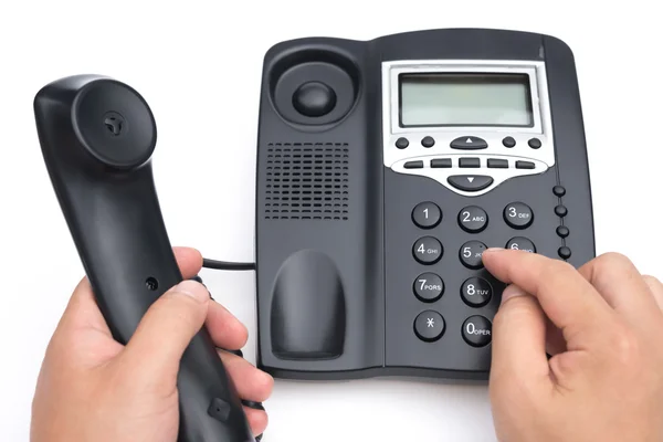 Man dialing a black telephone on a white background — Stock Photo, Image