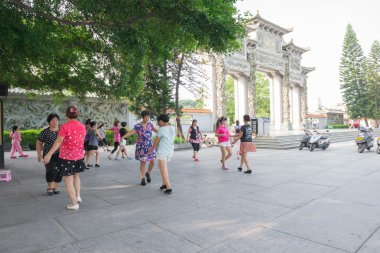 Çinli kadın sabah bir park önünde dans