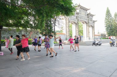 Çinli kadın sabah bir park önünde dans