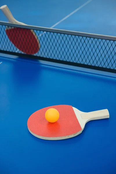 Raquetas de pingpong y pelota en una mesa de pingpong azul — Foto de Stock