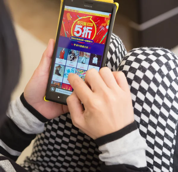 Yound woman shopping through mobile and getting 50% off — Stock Photo, Image