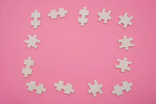 Skládačky puzzle ve tvaru rámečku na růžovém pozadí — Stock fotografie