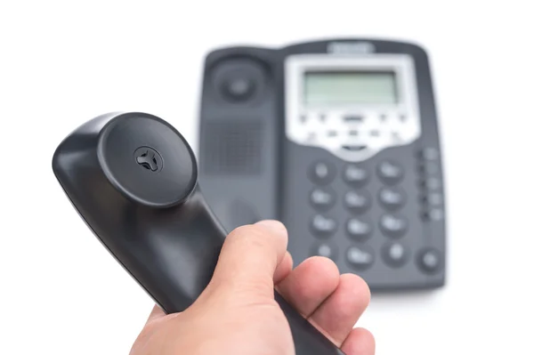 Homem segurando um receptor de telefone preto em um fundo branco — Fotografia de Stock