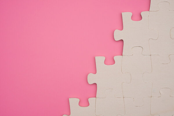 jigsaw puzzle on a pink background with copy space