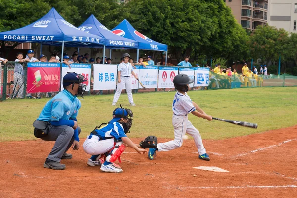 ZHONGSHAN PANDA CUP, ZHONGSHAN, GUANGDONG-July 23: batter of team BeiJing TianTan DongLi Primary School missed the ball during a match of 2015 National Baseball Championship Group A of Panda Cup against BeiJing TuanJieHu Primary School on July 23 2015 — стоковое фото