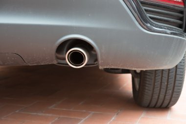 Gümüş bir otomobilin egzoz borusu
