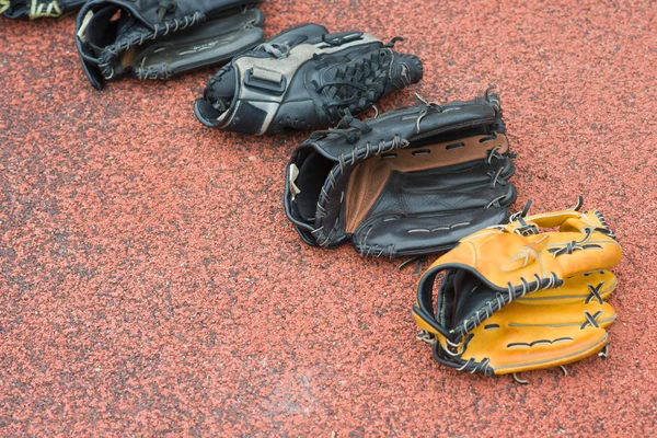 Luvas de beisebol em um fundo de borracha — Fotografia de Stock