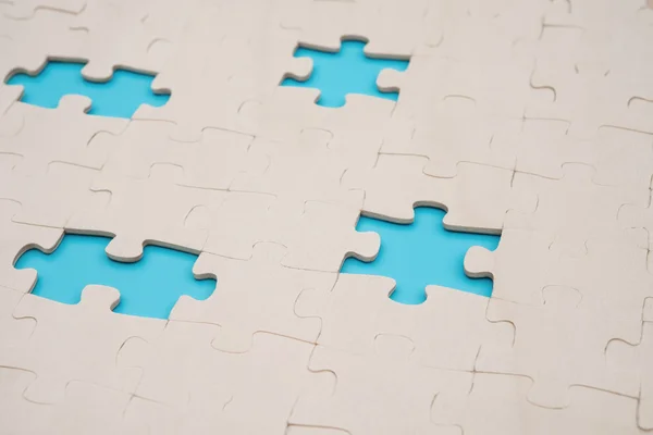 Rompecabezas con 4 piezas perdidas en el fondo azul —  Fotos de Stock