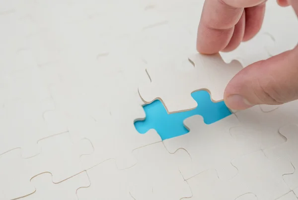 Het laatste stukje van een puzzelspel op blauwe afwerking — Stockfoto