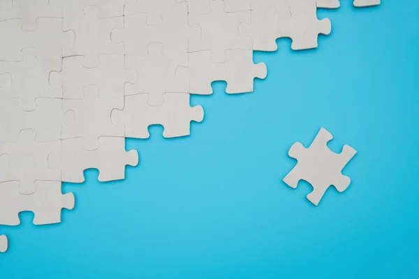 Puzzel met één stuk gescheiden op een blauwe achtergrond — Stockfoto