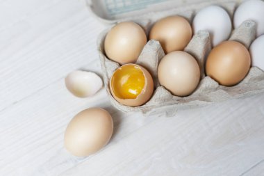 Karton tepside taze tavuk yumurtası, bir yumurta kırılır..