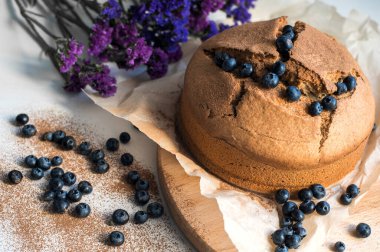 Masanın üzerinde taze tarçınlı kek ekmeği var. Yukarıdan yatay görüntü. Yaban mersiniyle süslenmiş..