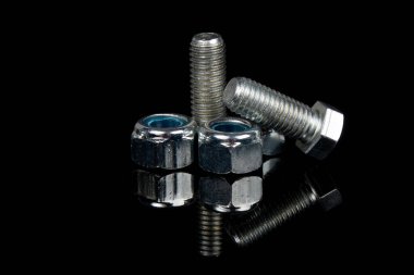 Siyah arka planda çelik cıvata ve fındık. Donanım.