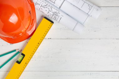 Güvenlik kaskı, inşaat seviyesi, kalem ve kopya alanı olan mühendislik çizimleri