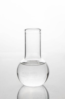 Beyaz bir masada tıbbi cam matara. Tıp araştırma laboratuvarı.