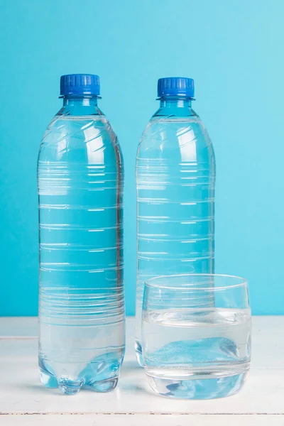 Plastflaska Med Friskt Vatten Och Glas Med Vatten Blå Bakgrund — Stockfoto